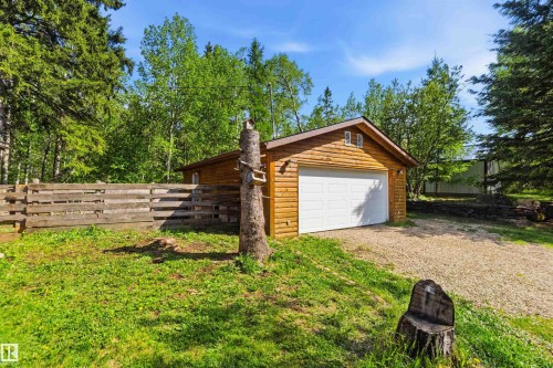 Detached wooden garage with a white overhead door and twin attic windows - #17 A 15031 Twp Road 462, Rural Wetaskiwin County, AB - Outdoor