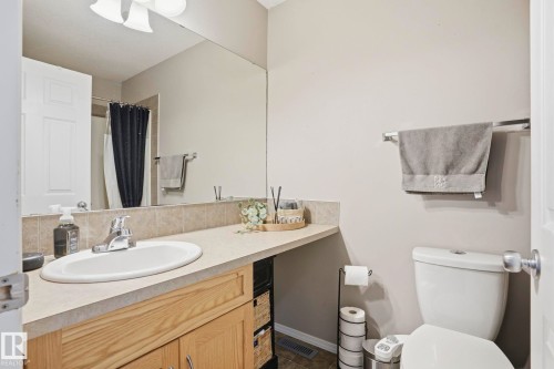 Bathroom vanity with an integrated sink, laminate countertop, and wood-finish cabinetry - 164 150 Edwards Drive, Edmonton, AB - Indoor Photo Showing Bathroom