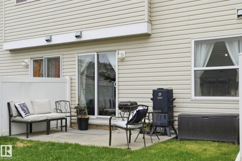 Concrete patio featuring a sliding glass door, an additional window, and horizontal vinyl siding - 164 150 Edwards Drive, Edmonton, AB - Outdoor With Exterior