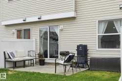 Concrete patio featuring a sliding glass door, an additional window, and horizontal vinyl siding - 