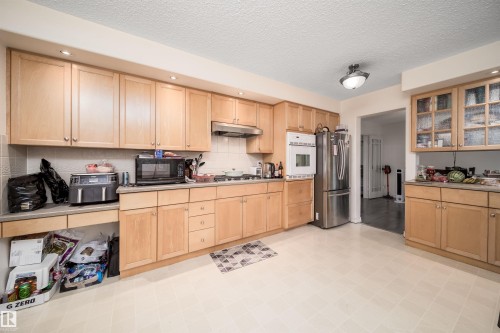Kitchen featuring wood-finish cabinetry, light-toned countertops, and recessed lighting - 6403 132 Street, Edmonton, AB - Indoor Photo Showing Kitchen