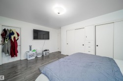 Spacious room featuring wood-finish flooring and a ceiling-mounted light fixture - 