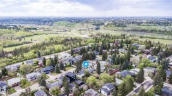Aerial perspective showcasing a residential neighborhood with mature trees, established streets, and a variety of architectural styles - 