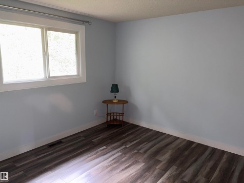 Room featuring a large window with white trim, wood-finish flooring, light blue painted walls, and white baseboards - 167 Ridgewood, St. Albert, AB - Indoor Photo Showing Other Room