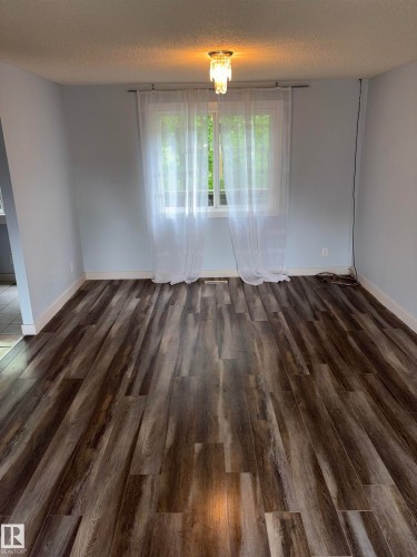 Spacious interior room featuring wood-finish flooring, light blue wall paint, and crisp white baseboards - 167 Ridgewood, St. Albert, AB - Indoor Photo Showing Other Room