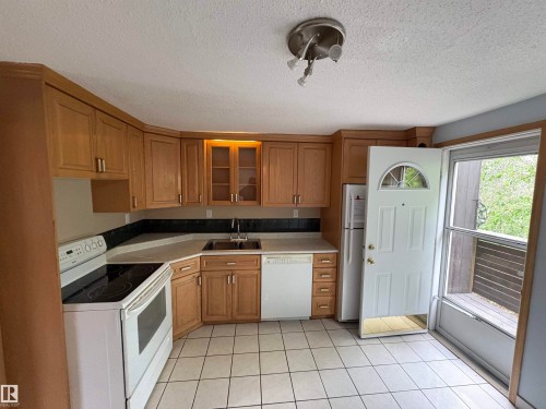 Kitchen featuring tile flooring, light wood-finish cabinetry with some glass-front doors, white appliances, and a built-in sink - 167 Ridgewood, St. Albert, AB - Indoor Photo Showing Kitchen
