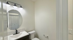 Bathroom featuring a white vanity with an integrated sink, a dark wood-finish cabinet, and a black faucet - 