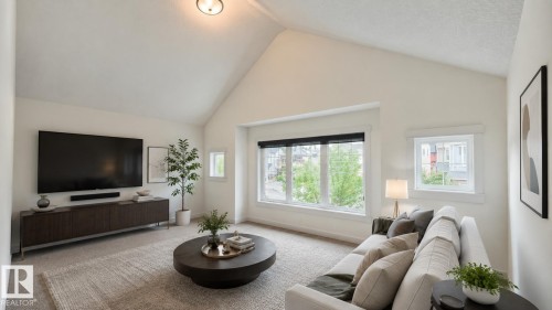 Vaulted ceiling living space featuring a large picture window, additional side windows, recessed lighting, and soft neutral carpeting - 3962 Claxton Loop, Edmonton, AB - Indoor Photo Showing Living Room