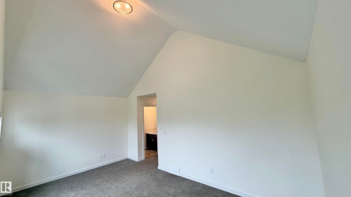Vaulted ceiling room featuring neutral-toned walls, gray carpet flooring, and a flush-mount ceiling light fixture - 3962 Claxton Loop, Edmonton, AB - Indoor Photo Showing Other Room