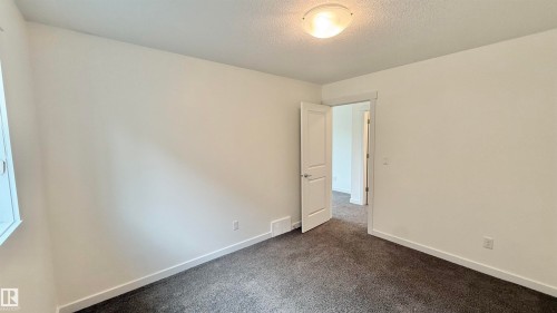 Neutral-toned interior room featuring textured carpet flooring, white walls, and a single window - 3962 Claxton Loop, Edmonton, AB - Indoor Photo Showing Other Room