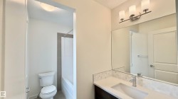 Bathroom vanity featuring a rectangular undermount sink, a chrome single-handle faucet, and a light-toned countertop - 