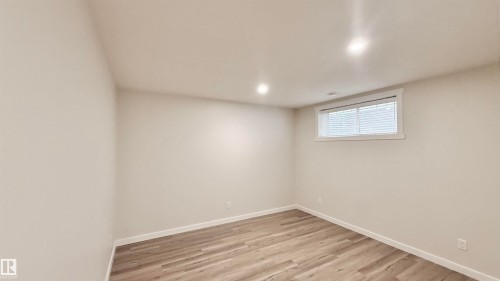 Neutral-toned room featuring recessed lighting and wood-finish flooring - 3962 Claxton Loop, Edmonton, AB - Indoor Photo Showing Other Room