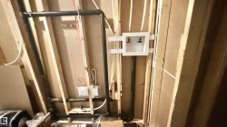 Framed interior wall featuring visible plumbing and electrical rough-ins - 