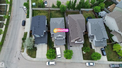 Contemporary residence featuring a dark shingle roof, light-colored siding, and a paved driveway - 3962 Claxton Loop, Edmonton, AB - Outdoor With View