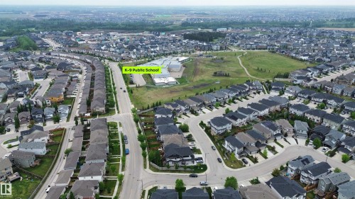 Aerial perspective showcasing a residential development with a K-9 Public School, extensive green spaces, and organized street patterns - 3962 Claxton Loop, Edmonton, AB - Outdoor With View