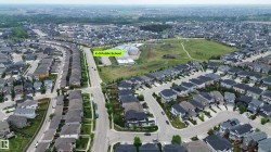 Aerial perspective showcasing a residential development with a K-9 Public School, extensive green spaces, and organized street patterns - 