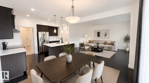 Open-concept living space featuring dark wood-finish flooring throughout - 3962 Claxton Loop, Edmonton, AB - Indoor Photo Showing Dining Room