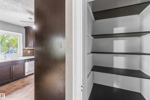 Built-in pantry featuring white interior walls and dark-toned shelving - 11842 93 Street, Edmonton, AB 
