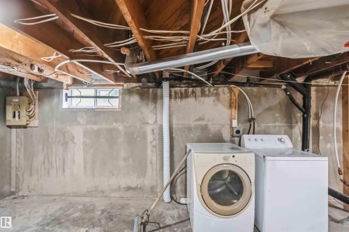 Utility area featuring exposed wood ceiling joists, a small casement window, and a concrete floor - 11842 93 Street, Edmonton, AB 