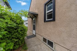 Stucco exterior featuring a side entrance with an awning - 