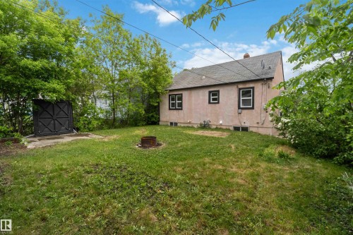 Expansive grassy yard area with a built-in fire pit - 11842 93 Street, Edmonton, AB 