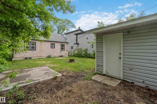 Detached garage with horizontal siding, a single entry door, and an overhead soffit - 11842 93 Street, Edmonton, AB 