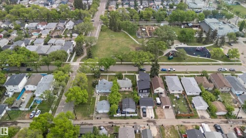 Aerial perspective showcasing a residential neighborhood with mature tree-lined streets, multiple detached homes with varying roof styles, and individual driveways - 11842 93 Street, Edmonton, AB 