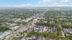 Expansive aerial perspective showcasing a verdant urban environment with a mix of residential and commercial structures - 