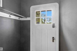 White panel door with multi-pane window, smart lock, and traditional knob hardware - 