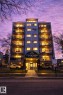 Modern multi-story building featuring individual balconies with black railings, a covered main entrance with signage, and integrated ground-level parking - 202 8310 Jasper Avenue, Edmonton, AB  - Indoor Photo Showing Other Room 