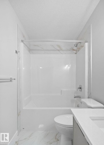 Bathroom featuring a white bathtub/shower combination with a chrome shower head and fixtures - 1511 211 Street Nw, Edmonton, AB 