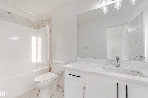 White vanity with a rectangular undermount sink, a chrome faucet, and black hardware - 1511 211 Street Nw, Edmonton, AB 