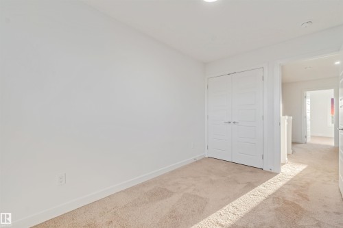 Recessed lighting illuminates neutral carpeting and white walls - 1511 211 Street Nw, Edmonton, AB 
