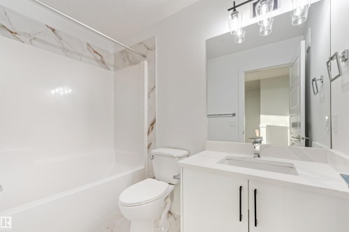 White vanity with a built-in rectangular sink, chrome faucet, and quartz countertop - 1511 211 Street Nw, Edmonton, AB 