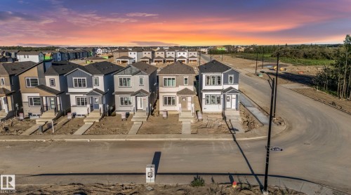 Newly constructed homes featuring modern architectural designs, varied exterior finishes, and concrete sidewalks - 1511 211 Street Nw, Edmonton, AB 