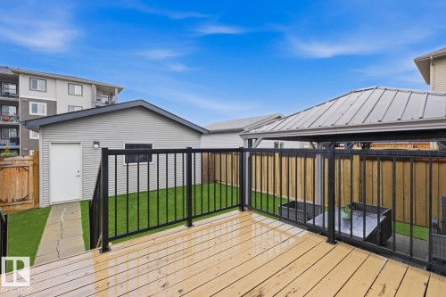 Wood-finish deck with black metal railing, featuring a covered pergola with a metal roof - 17844 61 Street, Edmonton, AB 