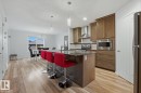 Kitchen featuring a central island with a stone-finish countertop and undermount sink - 17844 61 Street, Edmonton, AB 