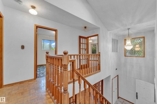 Interior staircase featuring wood-finish balusters and handrails - 10819 54 Avenue, Edmonton, AB 