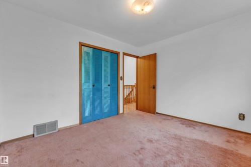 Interior room featuring a flush-mount ceiling light fixture, white walls, and pink carpet flooring - 10819 54 Avenue, Edmonton, AB 