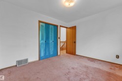Interior room featuring a flush-mount ceiling light fixture, white walls, and pink carpet flooring - 