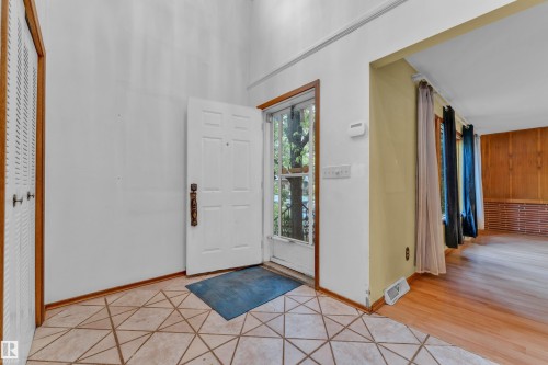 Foyer featuring geometric tile flooring and a white paneled entry door with a screen door - 10819 54 Avenue, Edmonton, AB 
