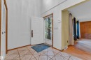 Foyer featuring geometric tile flooring and a white paneled entry door with a screen door - 10819 54 Avenue, Edmonton, AB 
