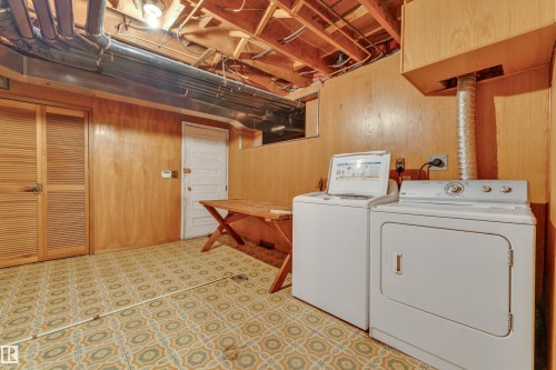 Utility area featuring a patterned floor, wood-paneled walls, exposed ceiling joists, and a louvered bi-fold door - 10819 54 Avenue, Edmonton, AB 