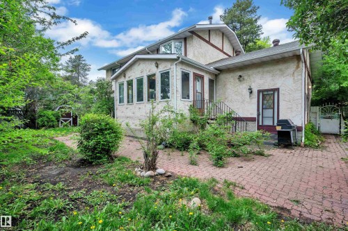 Stucco exterior residence with a sunroom featuring multiple windows - 10819 54 Avenue, Edmonton, AB 