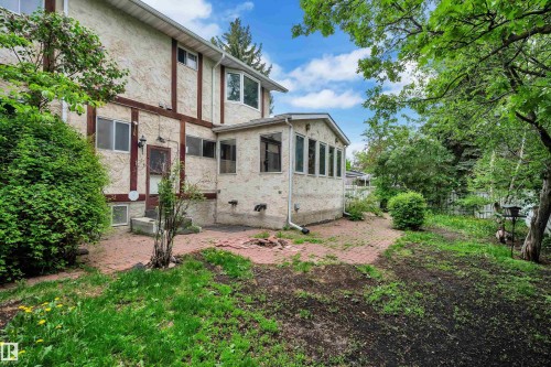 Rear exterior featuring textured stucco siding and decorative dark wood trim - 10819 54 Avenue, Edmonton, AB 