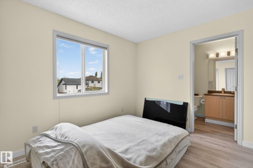 Room featuring light wood-finish flooring, a window with white trim, and a textured ceiling - 21244 90 Avenue, Edmonton, AB 