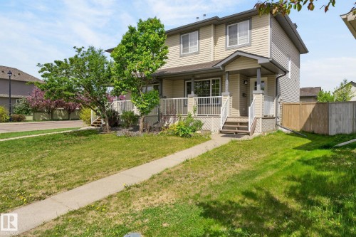 Two-story residence featuring light-toned siding and a covered front entry porch with white railings - 21244 90 Avenue, Edmonton, AB 