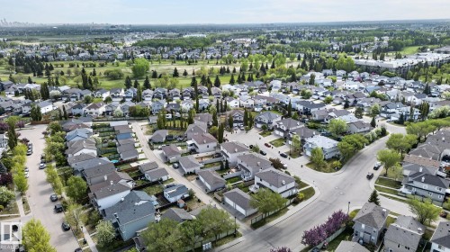 Aerial perspective showcasing a developed residential neighborhood with a variety of single-story and multi-story homes - 21244 90 Avenue, Edmonton, AB 