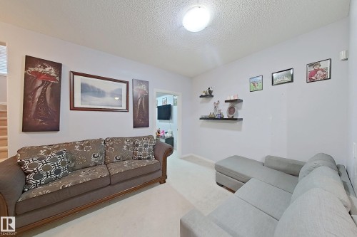 Living area featuring light wall paint, carpet flooring, and a flush-mount ceiling light - 41 5102 30 Avenue, Beaumont, AB 