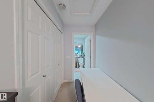 Hallway featuring neutral wall colors, bi-fold closet doors, and light-colored flooring - 41 5102 30 Avenue, Beaumont, AB 